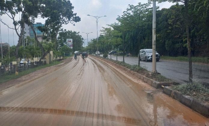 Situasi jalan Raja Isa, Batam Center yang diselimuti lumpur atau tanah. Tampak beberapa kendaraan yang melintas berhati-hati karena permukaan jalan licin. Foto : ubay
