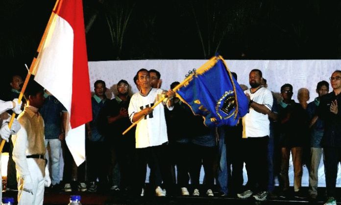 Ketua PWI Batam Agus Bagjana mengibarkan bendera PWI usai dilantik Ketua PWI Provinsi Kepri Andi Gino di Hotel Ibis Style Batam. Foto : dok