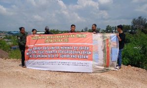 Warga Tanjungsengkuang memasang spanduk protes terhadap PT Superland Batam yang selama ini memanfaatkan ROW 30 untuk tempat parkir alat berat didalam kawasan pergudangan. Foto : ubay