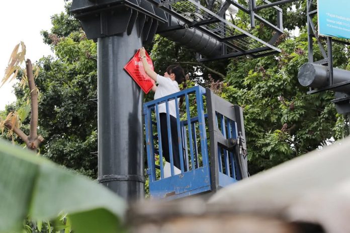 Wakil Walikota Batam Li Claudia Chandra memasang tanda penyegelan di baliho. Foto : ist