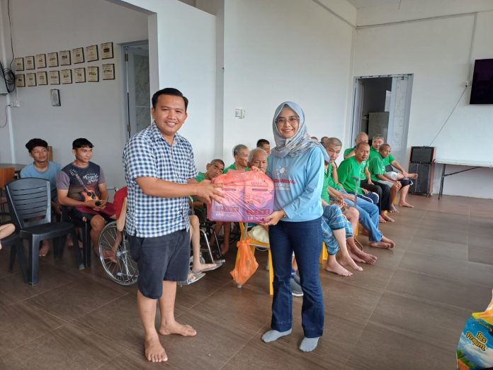 Ketua MPI Provinsi Kepri Susanna memberikan paket sembako ke yayasan Lansia True Love secara simbolis dan diterima oleh pembina yayasan Wilson. Foto : Tengku Bayu