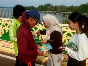 Karyawan BPR Kepri Bintan memberikan flayer kepada warga yang tengah olahraga. Foto : ist