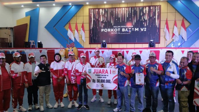 Wali Kota Batam sekaligus Kepala BP Batam, Amsakar Achmad memberikan hadia kepada perwakilan Kecamatan Sekupang yang dinyatakan sebagai juara Umum PORKOR Batam VI Tahun 2025. Foto Tengku Bayu