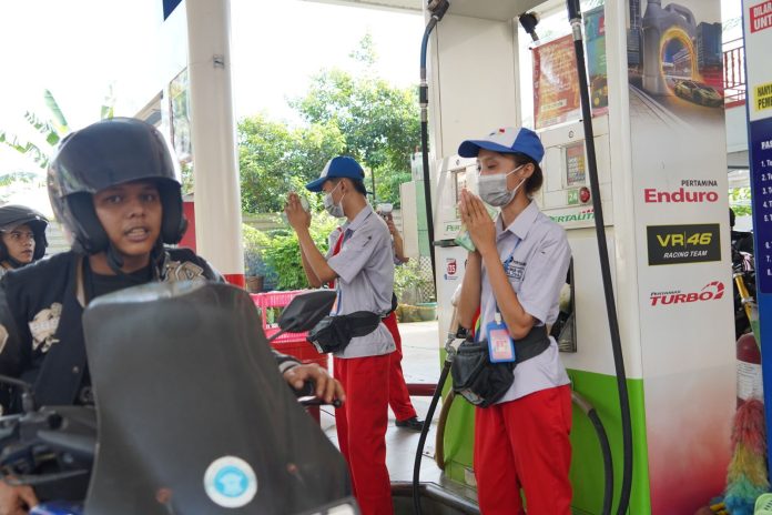 Petugas Pertamina tengah melayani masyarakat membeli BBM. Foto : ist