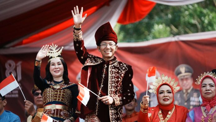 Kepala BP Batam sekaligus Wali Kota Batam, Amsakar Achmad, didampingi Wakil Kepala BP Batam sekaligus Wakil Wali Kota Batam, Li Claudia Chandra melambaikan tangan kepada seluruh peserta pawai pembangunan dalam rangka menyambut HUT RI ke 81 Tahun. Foto : ist